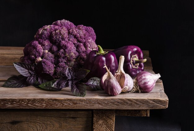 Verse groente. Donkerpaarse paprika, bloemkool met blaadjes basilicum en knoflook