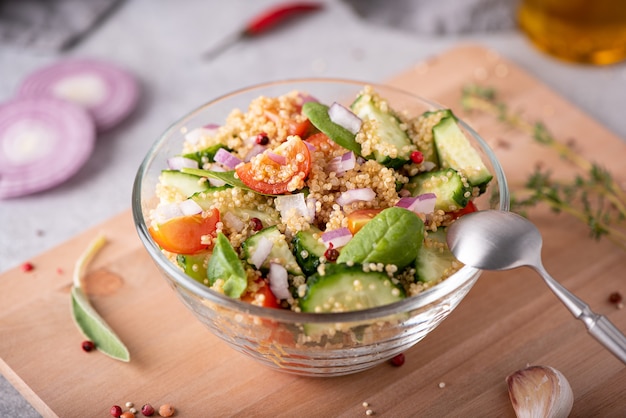 Verse groente en quinoa salade in een glazen kom op tafel, close-up