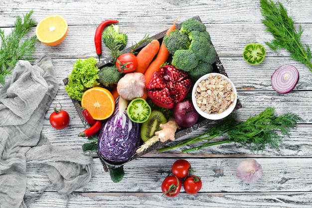 Verse groenten en fruit in een houten kist op een witte houten achtergrond biologisch voedsel bovenaanzicht gratis kopieerruimte