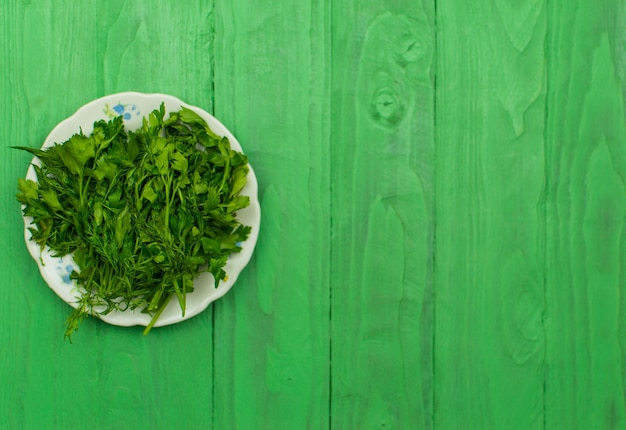 Verse groenten in een bord op een lichtgroene houten ondergrond