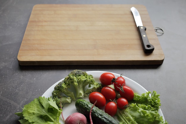 Verse groenten in een witte plaat op een grijze tafel