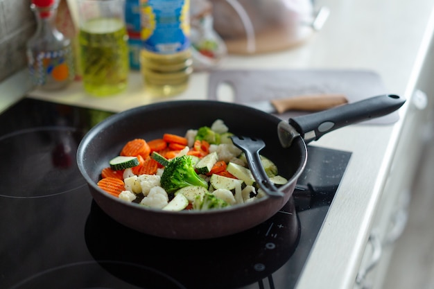 Verse groenten koken op pan thuis keuken. Detailopname.