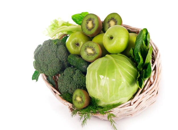 Verse groenten met bladeren - broccoli, kiwi, selderij, spinazie, boerenkool, druiven en appel geïsoleerd op een witte achtergrond