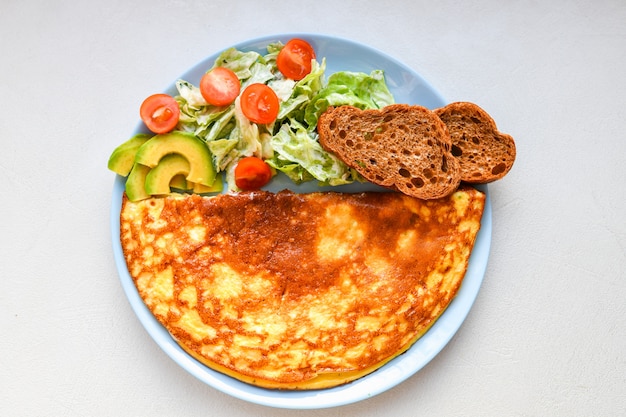 Verse groenten met roerei. op een ronde plaat. Omelet met champignons