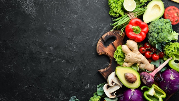 Verse groenten op een zwarte achtergrond. Vegetarisch eten. Bovenaanzicht. Vrije ruimte voor uw tekst.