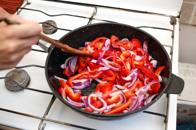 Verse groenten, paprika's en uien in een koekenpan, koken thuis sovjet-unie keuken