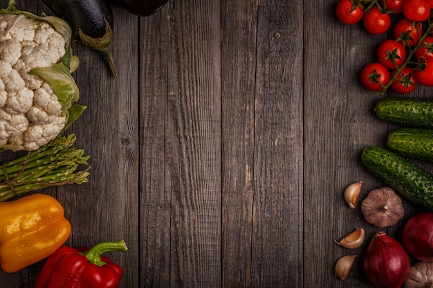 Verse groenten voor het koken op donkere houten tafel