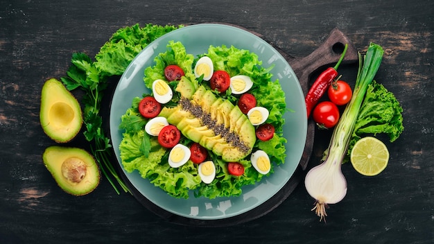 Verse groentesalade Avocado cherrytomaatjes sla kwarteleitjes Op een houten achtergrond Bovenaanzicht Gratis kopieerruimte