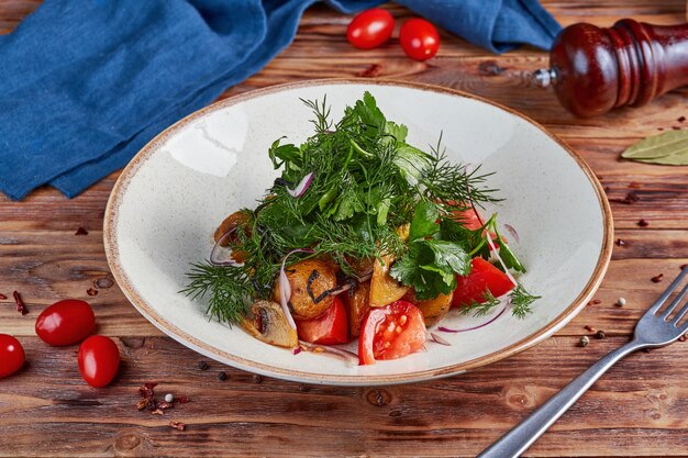 Verse groentesalade met gebakken aardappelen en champignons, houten