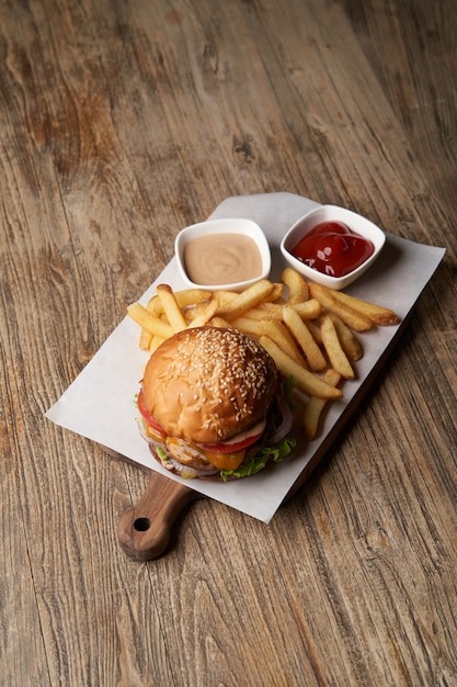 Verse hamburger en frietjes op houten snijplank. Fast Food, junkfood