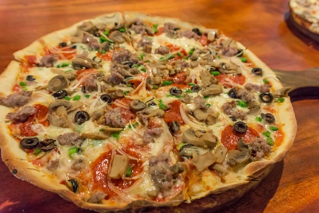 Verse, handgemaakte pizza met ovengeroosterde tomaten, paprika, kappertjes, basilicum en geschaafde kaas