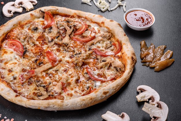 Verse heerlijke Italiaanse pizza met champignons en tomaten op een donkere betonnen ondergrond. Italiaanse keuken