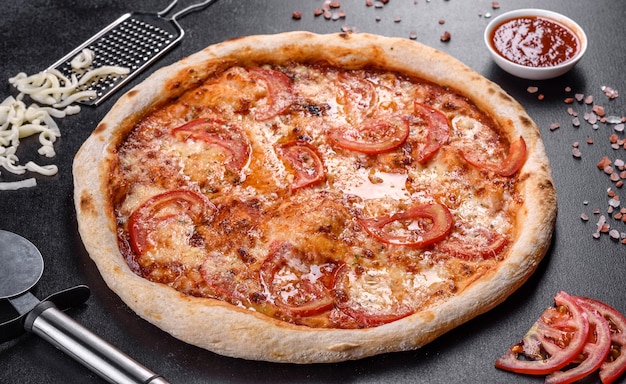 Verse heerlijke Italiaanse pizza met champignons en tomaten op een donkere betonnen ondergrond. Italiaanse keuken