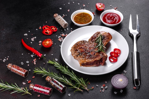 Verse heerlijke sappige biefstuk op de botten met groenten en kruiden Varkensvlees sappige steak grill op donkere tafel