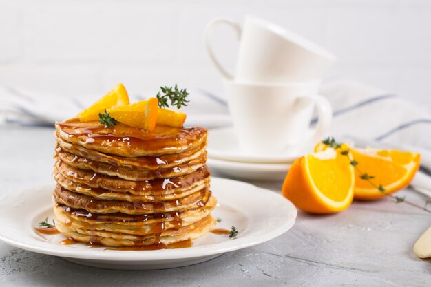 Verse heerlijke zoete Amerikaanse pannenkoeken op een plaat met vers fruit en stroop. Voor ontbijt