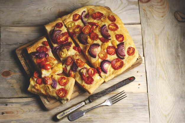 Verse huisgemaakte focaccia met blauwe uien en kerstomaatjes.