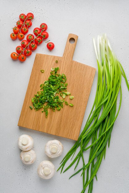 Verse ingrediënten bereid voor het koken van tomaten-sjalottenchampignon op een houten bord