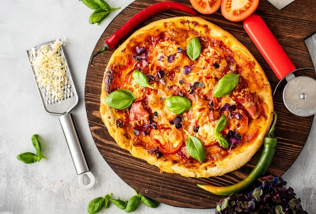Verse Italiaanse pizza met spek, tomaat en basilicum.