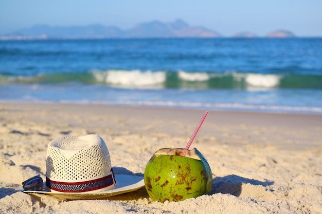 Verse jonge kokosnoot met strohoed en zonnebril op het strand van Copacabana Rio de Janeiro Brazilië