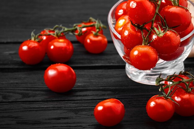 Verse kerstomaatjes op een donkere tafel, mooie verse tomaten met dauw druppels.