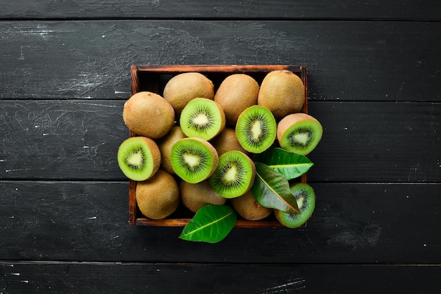 Verse kiwi en groene bladeren op tafel Rustieke stijl Fruit Bovenaanzicht Vrije ruimte voor tekst