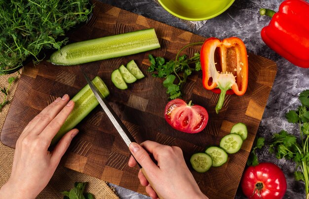 Verse komkommer snijden op houten snijplank met Japans mes groentesalade maken