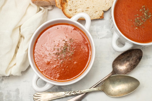 Verse koude tomatensoep met kruiden in de kom