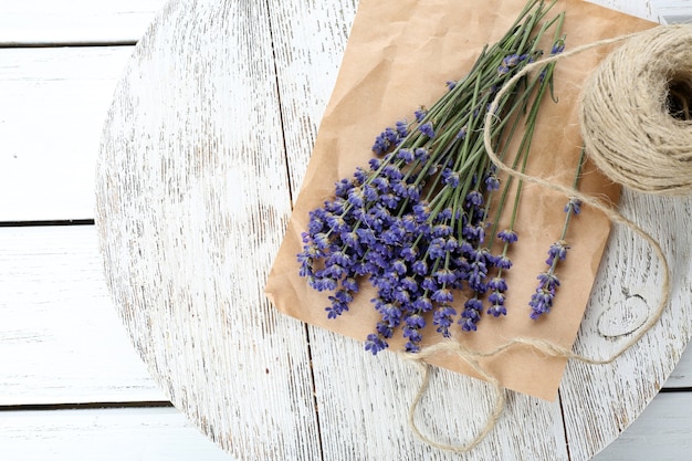 Verse lavendel met touw op perkament op houten tafel, close-up