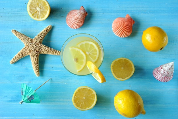 Verse limonade met zeester en zeeschelpen op blauwe lijst