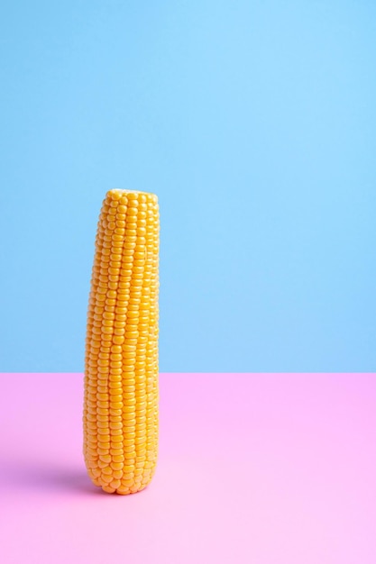 Verse maïs op een gekleurde achtergrond Verstrooide korrels helften van het product