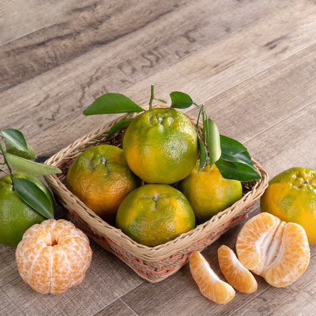 Verse mandarijn met verse bladeren op houten tafel