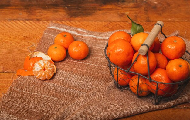 Foto verse mandarijnen in een metalen mand op een houten achtergrond