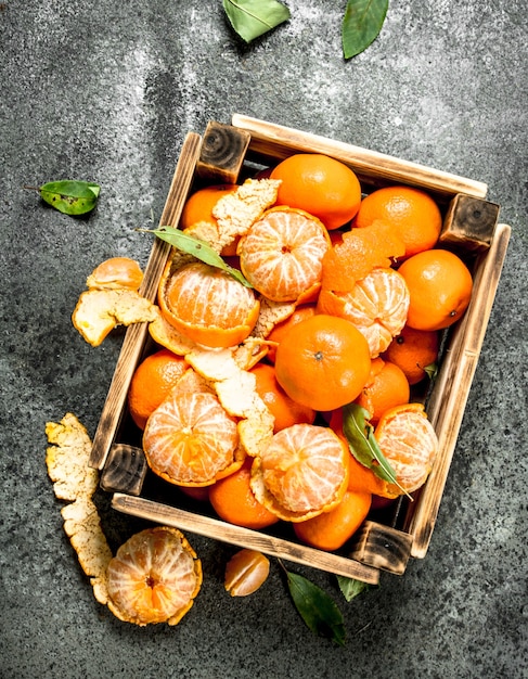 Verse mandarijnen in een oude doos op rustieke tafel.