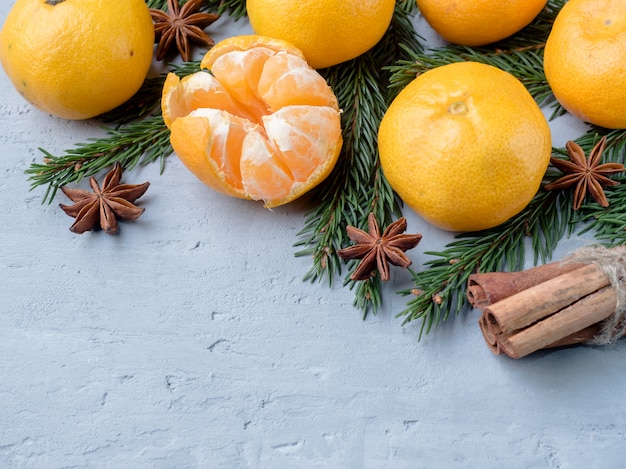Verse mandarijnen met takken van kerstboom, steranijs kaneel op grijs beton