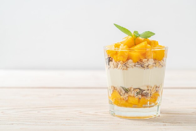 verse mangoyoghurt met granola in glas - gezonde voedselstijl