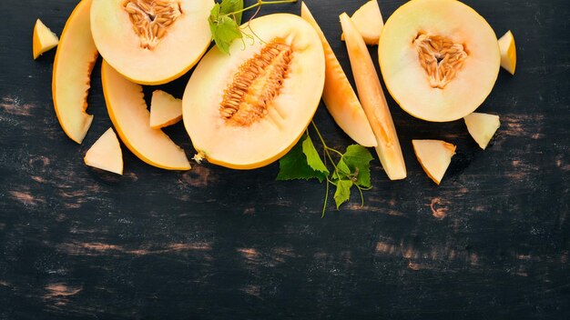 Verse meloen In stukjes gesneden meloen Op een zwarte houten achtergrond Vrije ruimte voor tekst Bovenaanzicht