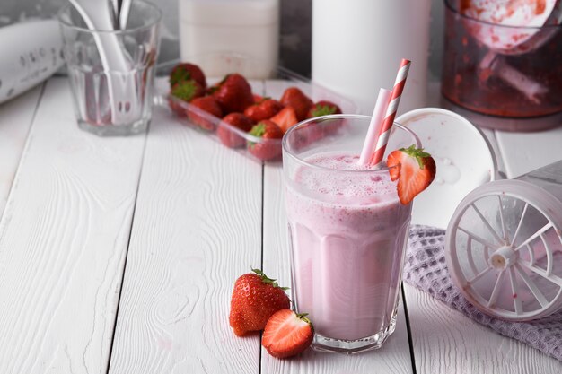 Verse milkshake met aardbeien op een lichte tafel.