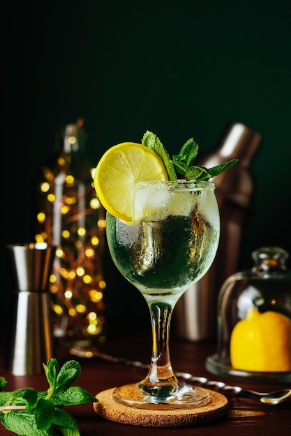 Verse mojito-cocktail met citroenrozemarijnmunt en ijs in kruikglas op donkerblauwe achtergrond summe