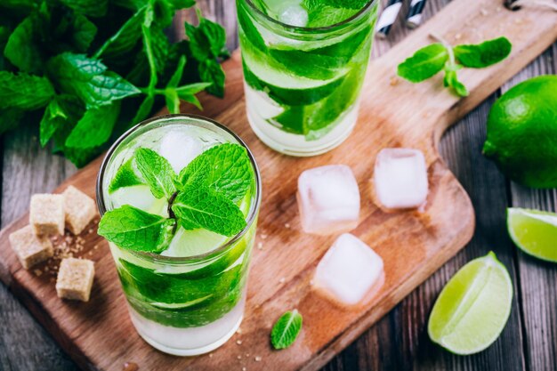 Verse mojitococktails met limoenmunt en ijs in glas op houten ondergrond