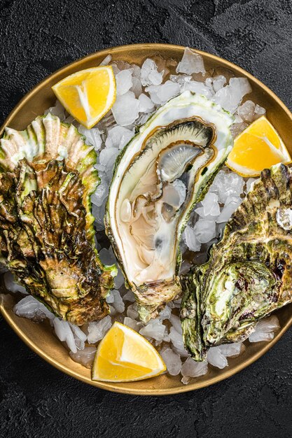 Verse oesters met citroen op ijs Donkere achtergrond Bovenaanzicht