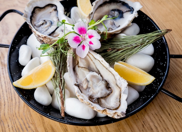 Verse oesters op een plaat met ijs en bloemen. Restaurant