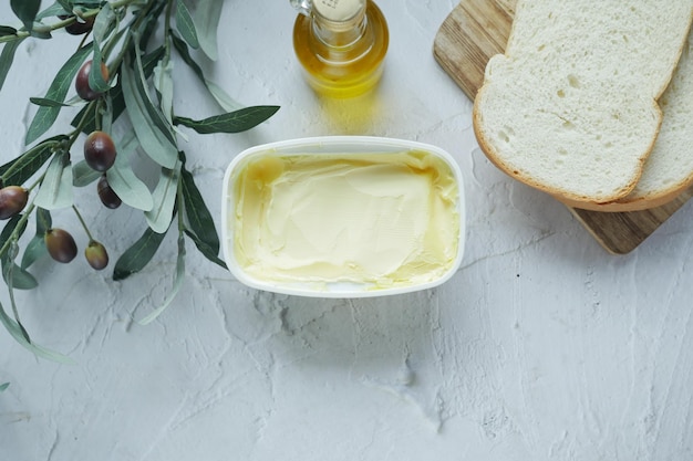 Verse olijfboter in een bakje met brood op witte achtergrond