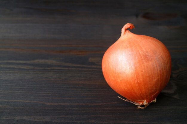 Verse ongeschilde ui geïsoleerd op donkere houten kleur