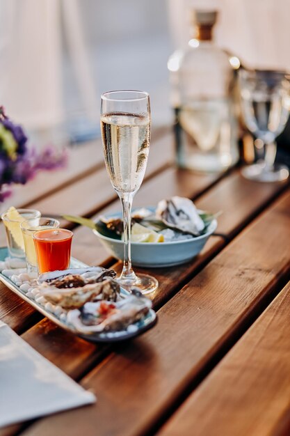 Verse open oesters met een glas gekoelde prosecco-wijn en een set scheut alcoholische cocktails geserveerd op tafel Zeevruchten delicios