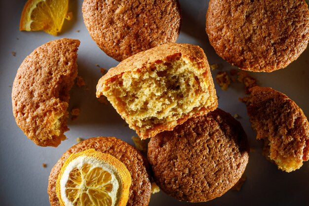 Verse oranje muffins op een ronde plaat.