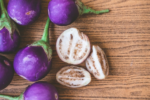 Verse paarse aubergines op houten tafel.