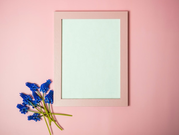 Verse paarse bloemen met lege roze fotolijst op roze achtergrond Mockup voor een idee Lege ruimte voor tekst of afbeelding