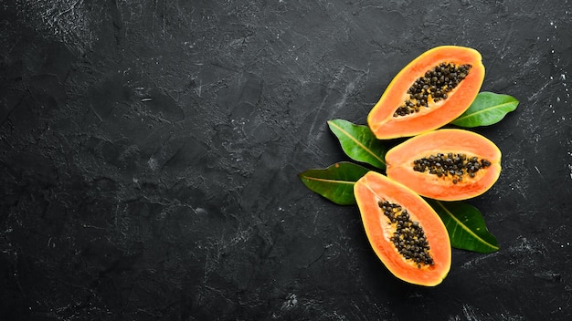 Verse papaya op een zwarte stenen achtergrond Tropisch fruit Bovenaanzicht Vrije ruimte voor tekst