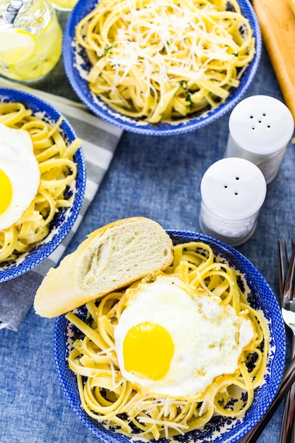 Verse pasta pangrattato met krokante eieren op tafel.