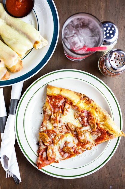 Verse pepperoni en worst pizza slice op tafel in Italiaans restaurant.